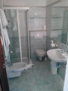 a bathroom with a toilet a sink and a bath tub at Hotel Azalea in Baveno