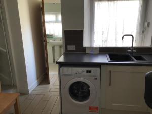 a kitchen with a washing machine and a sink at Cosy end terrace in Lancaster