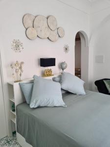 sypialnia z dużym łóżkiem z niebieskimi poduszkami w obiekcie Casa Leucosia Suites w mieście Capri +20 zdjęć