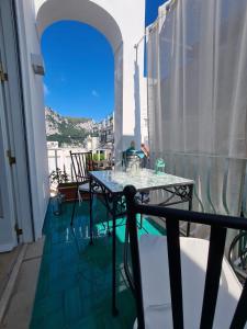 balkon ze stołem i krzesłami w obiekcie Casa Leucosia Suites w mieście Capri
