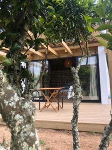 a wooden deck with a picnic table in front of a house at SeaHouseNature in Porto Covo +7 photos
