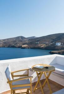 a table and chairs on a balcony with a view of the ocean at Kalderimi Residencies in Astypalaia