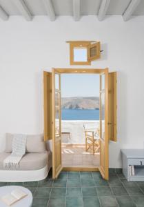 a living room with a door open to a view of the ocean at Kalderimi Residencies in Astypalaia