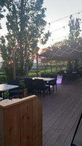 a deck with tables and chairs and an umbrella at Hotel de Plank in Noorbeek