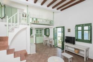 un soggiorno con una scala e una televisione di Kalderimi Residencies a Astypalaia Town