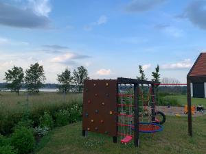 a playground with a rock wall and a climbing frame at Luksusowy apartament Ryn Mazury Widok na Jezioro, Gorąca BALIA in Ryn