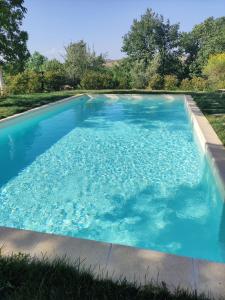 a swimming pool with blue water in a yard at Agriturismo La Poderina in Bagno Vignoni
