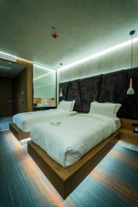 two large beds in a room with a large mirror at Pinea Hotel Resort & Spa in Golem