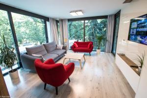 salon z kanapą i czerwonymi krzesłami w obiekcie Apartament Unia 12 Basen&SPA w mieście Lublin