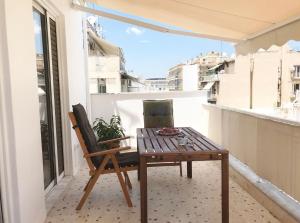 a wooden table and chair on a balcony at Athens by foot: Perfect flat with terrace in Athens