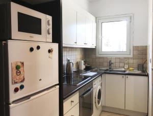 a kitchen with a refrigerator and a microwave at Athens by foot: Perfect flat with terrace in Athens