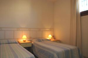 two beds in a room with two lamps on them at Stella Marina 2 in San Teodoro