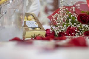 un tavolo con un mazzo di rose e una scatola d'oro di Pousada de Itaipava a Itaipava