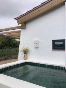 a pool of water next to a white building at SeaHouseNature in Porto Covo