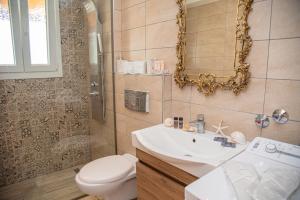 a bathroom with a sink and a toilet and a mirror at Nausika Cottage Corfu in Paleokastritsa +72 photos