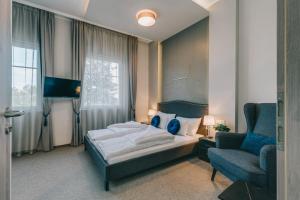 um quarto com uma cama, uma cadeira e uma televisão em Villa17 em Badacsonytomaj