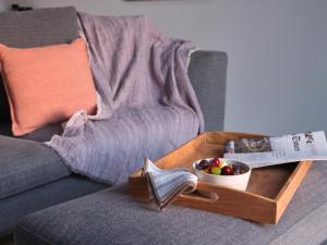a tray with a book and a bowl of fruit on a couch at Karino Suite in Naousa