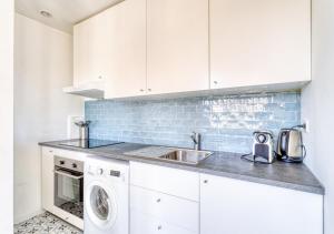 a white kitchen with a sink and a dishwasher at COCON de DOUCEUR entre DISNEY et PARIS in Villiers-sur-Marne