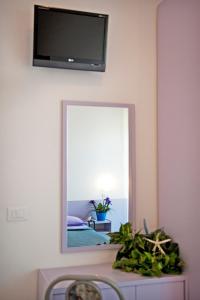 espejo en la pared con TV en la pared en Hotel Aurea, en Bellaria-Igea Marina