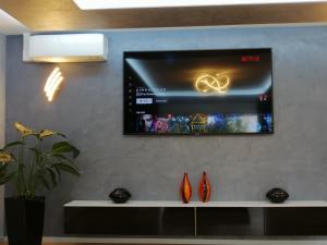 a flat screen tv on a wall with vases at Luxus Wohnung in der Nähe von Frankfurt in Kelkheim