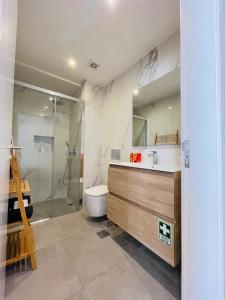 een badkamer met een douche, een toilet en een wastafel bij Living Funchal Apartments in Funchal