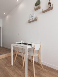 una mesa blanca y sillas en una habitación en Lamartine Quai Saône - Centre Ville - Pont St Laurent, en Mâcon