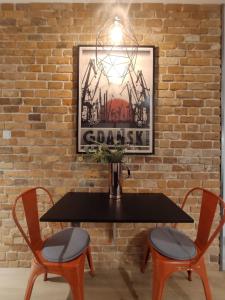 a black table with two chairs and a vase on it at Red wall apartment in the Old Town in Gdańsk