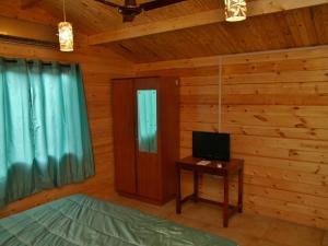 a bedroom with a bed and a desk with a television at Santonio Resorts in Anjuna