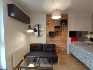 a living room with a couch and a bed at Red wall apartment in the Old Town in Gdańsk