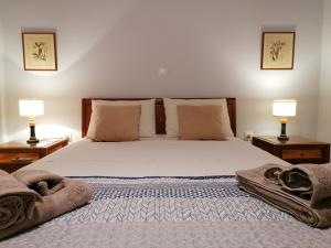 una camera da letto con un letto grande con due lampade di Vacation cozy home a Paralía Sergoúlas