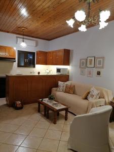 Vacation cozy home في Paralía Sergoúlas: غرفة معيشة مع أريكة وطاولة