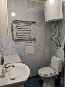 a bathroom with a white toilet and a sink at Уютная квартира возле CITY Mall in Zaporozhye