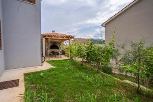 a backyard with a patio with a yard with grass at Apartment Livia in Cres
