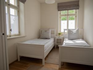 1 dormitorio con 2 camas y 2 ventanas en ferienwohnungen1886 en Borsdorf