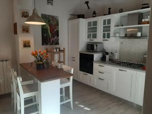 a kitchen with white cabinets and a table and a stove at Casa Vacanze Ada in Fiesole