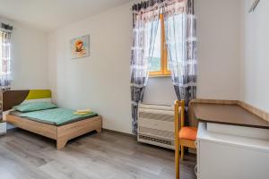 a small room with a bed and a window at Apartment Livia in Cres