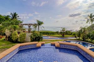 a resort swimming pool with a view of the ocean at Casa Cala Honda in Playa Junquillal