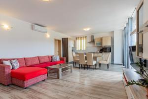 a living room with a red couch and a kitchen at Apartment Livia in Cres
