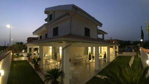 una grande casa bianca con patio di notte di InVilla Bed&Breakfast - Quality Rooms a Santa Maria di Castellabate