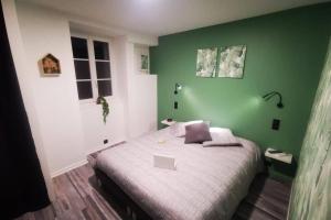 a green bedroom with a bed with a laptop on it at Au numéro 4 (le Flex) in Châteauroux