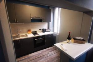- une petite cuisine avec une bouteille de vin sur un comptoir dans l'établissement Au numéro 4 (le Flex), à Châteauroux