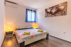 a bedroom with a bed and a painting on the wall at Apartment Livia in Cres