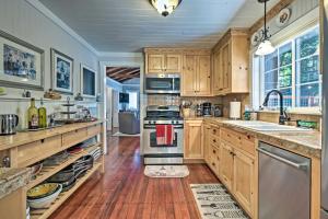 a kitchen with wooden cabinets and stainless steel appliances at Redwoods Cabin with Hot Tub Walk to Russian River! in Guerneville