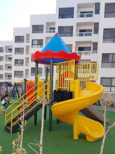 a playground with a slide and an umbrella at Porto Said in Port Said