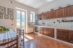a large kitchen with wooden cabinets and a table at Casa Gege', for up to 5 guests, shared pool, Sorrento center in Sorrento