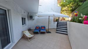two chairs and an umbrella on a patio at Annie's Apartment in Ialyssos