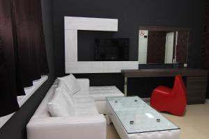 uma sala de estar com um sofá branco e uma cadeira vermelha em Bedroom Place Guest Rooms em Ruse