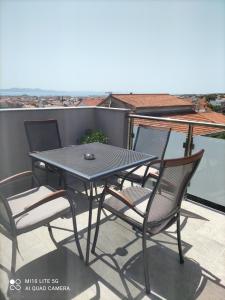 a patio table and chairs on a balcony at Apartment Marco in Zadar