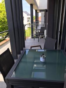 a glass table on a balcony with a view of a patio at Oasis Residence in Hajdúszoboszló