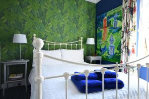 アニックにあるPercy Terrace Bed and Breakfastの緑の壁のベッドルーム1室(白いベッド1台付)